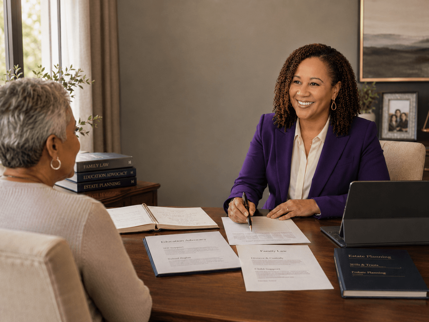 Smiling lawyer in purple blazer discusses legal documents with a client at a desk.